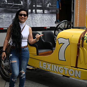 A fan poses with a Ragtime Racers Car